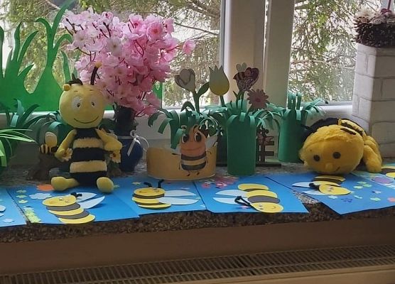 Na parapecie leżą prace plastyczne dzieci