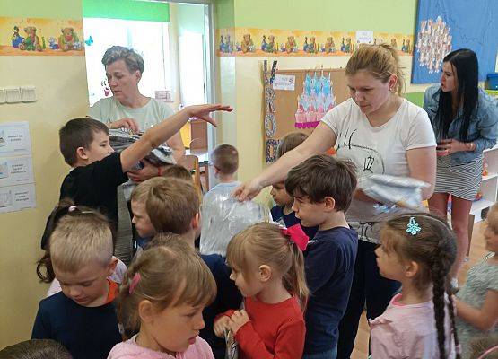 Kobieta rozdaje dzieciom obrazki