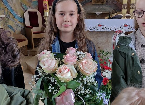 Uczennica trzyma kwiaty