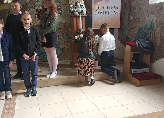 Uczniowie składają kwiaty pod figurką Matki Boskiej