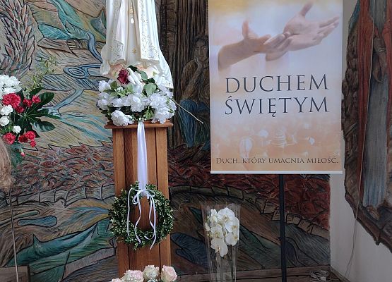 Złożone kwiaty pod figurą Matki Boskiej