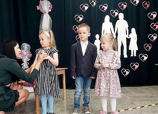 Nauczycielka podaje dziewczynce mikrofon