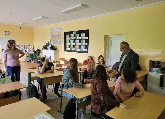 Pan dyrektor i pani dyrektor rozdają  cukierki dzieciom