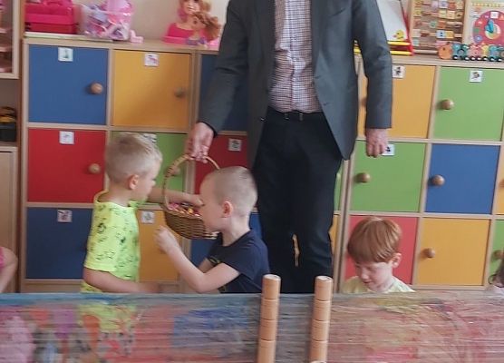 Pan dyrektor i pani dyrektor rozdają  cukierki dzieciom