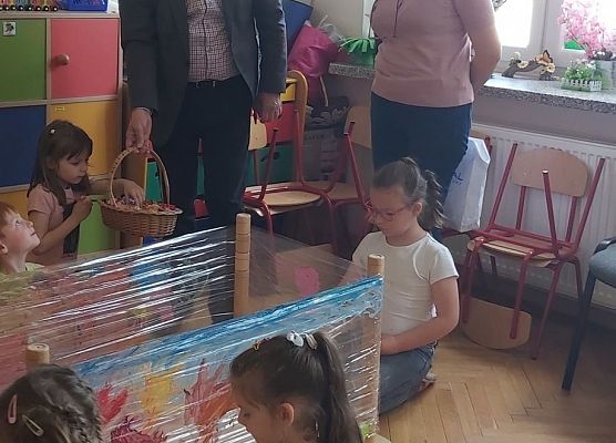 Pan dyrektor i pani dyrektor rozdają  cukierki dzieciom