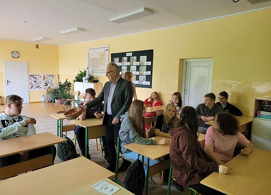 Pan dyrektor i pani dyrektor rozdają  cukierki dzieciom