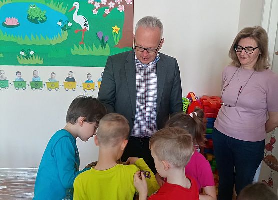 Pan dyrektor i pani dyrektor rozdają  cukierki dzieciom