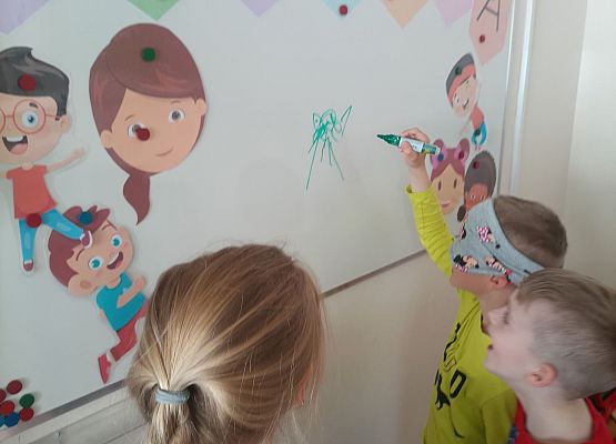 Chłopiec z zasłoniętymi oczami rysuje po tablicy