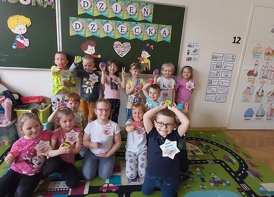 dzieci siedzą i pozują do zdjęcia