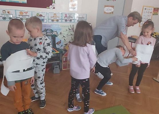 dzieci owijają się nawzajem  papierem