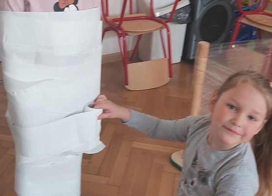 dziewczynka okręca papierem koleżankę