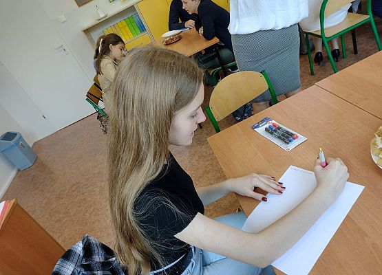 Uczniowie zapisują wnioski ze spotkania