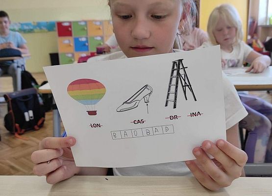 Uczennica prezentuje rozwiązany rebus