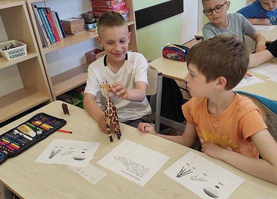Uczeń prezentuje papierową żyrafę