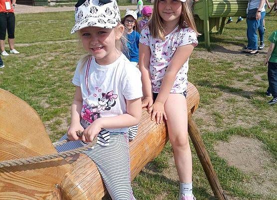 Dziewczynki siedzą na drewnianej zabawce