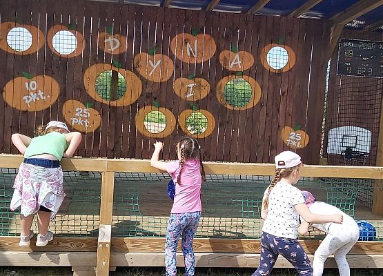 Dzieci stoją przy siatce do zabawy