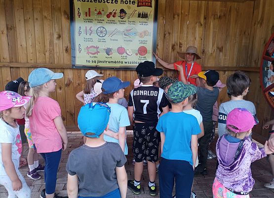 Dzieci stoją w grupie i słuchają animatorki