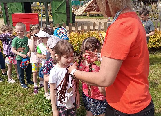 Animatorka rozdaje dzieciom medale