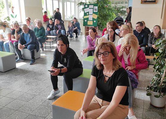 Wicedyrektor i rodzice oglądają występy artystyczne uczniów