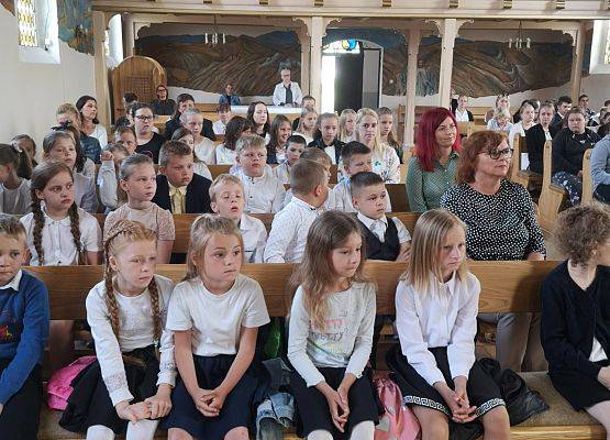 Uczniowie siedzą w kościele