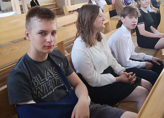 Uczniowie siedzą w kościele