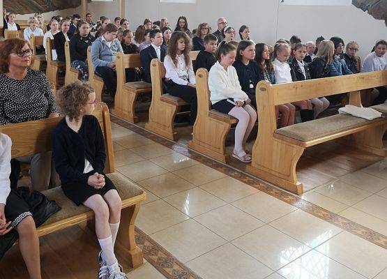 Uczniowie siedzą w kościele