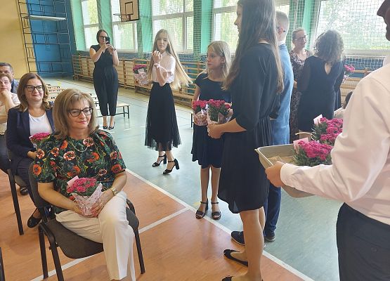 Uczniowie rozdają kwiaty