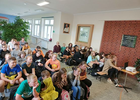 Uczniowie siedzą w holu