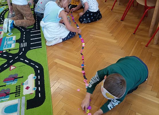 dzieci układają pociąg z guzików