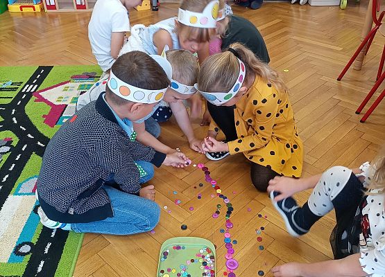 dzieci układają pociąg z guzików