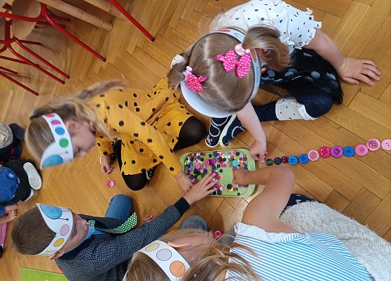 dzieci układają pociąg z guzików