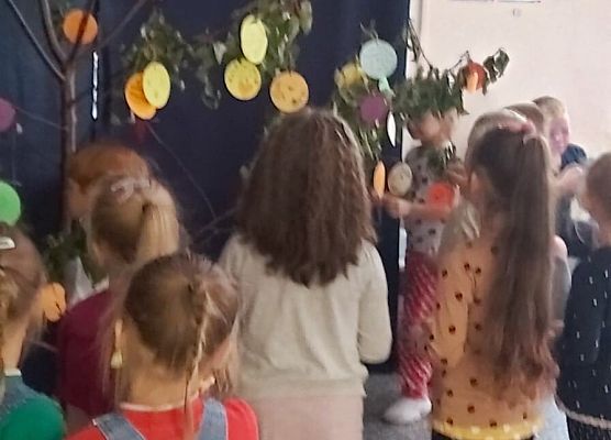 dzieci wieszają kropki na drzewie talentów