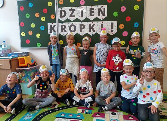 dzieci na tle tablicy z napisem dzień kropki