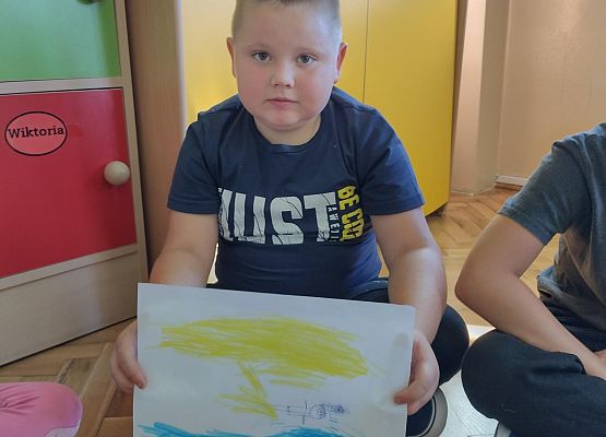 uczeń prezentuje rysunek wakacyjnych wspomnień