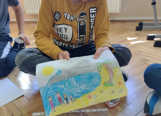 uczeń prezentuje rysunek wakacyjnych wspomnień