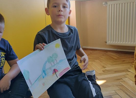 uczeń prezentuje rysunek wakacyjnych wspomnień