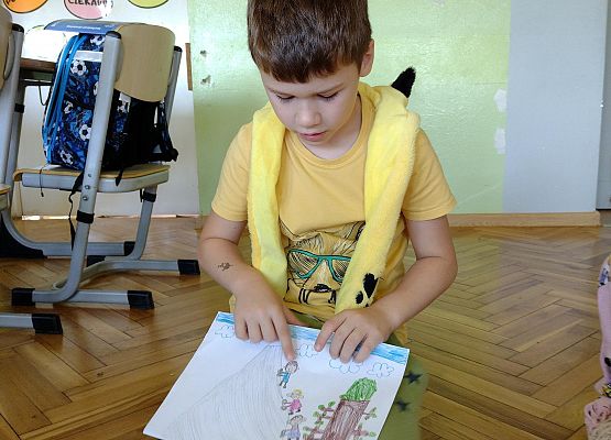 uczeń prezentuje rysunek wakacyjnych wspomnień