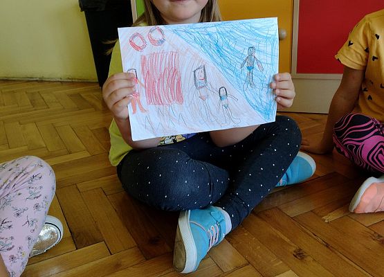 uczennica prezentuje rysunek wspomnień wakacyjnych
