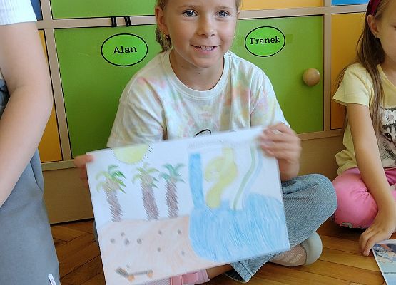 uczennica prezentuje rysunek wspomnień wakacyjnych