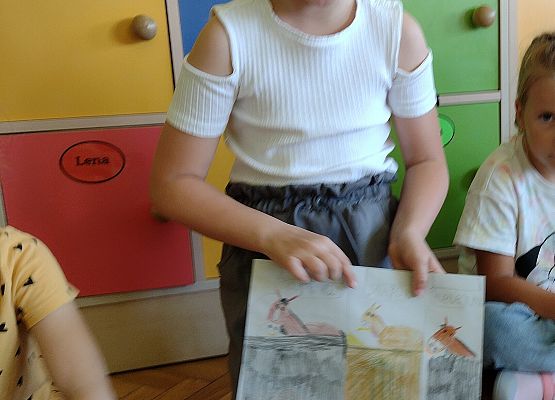 uczennica prezentuje rysunek wspomnień wakacyjnych