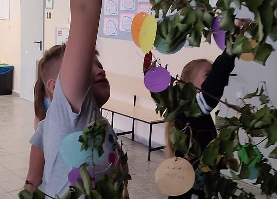 Uczniowie wieszają kropki na Drzewie Talentów