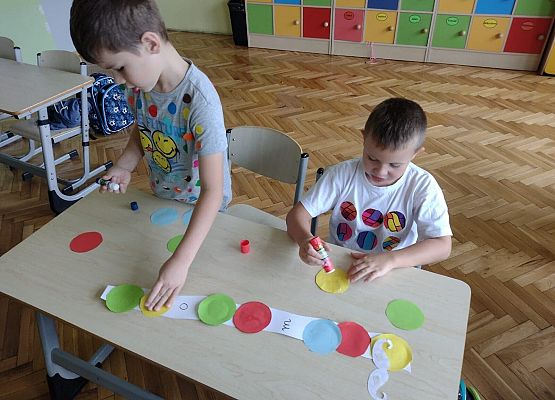 Chłopcy przyklejają kropki