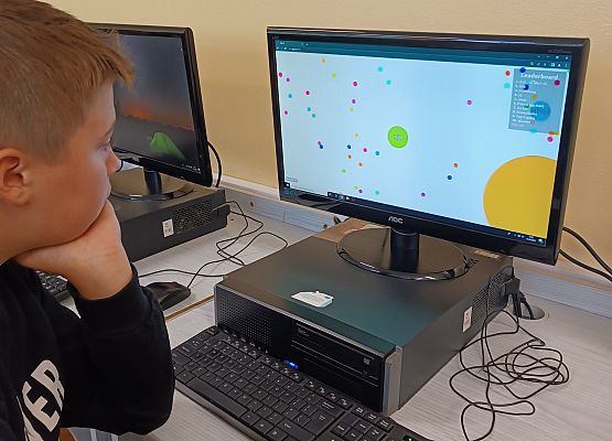 Chłopiec gra na komputerze w grę w kropki