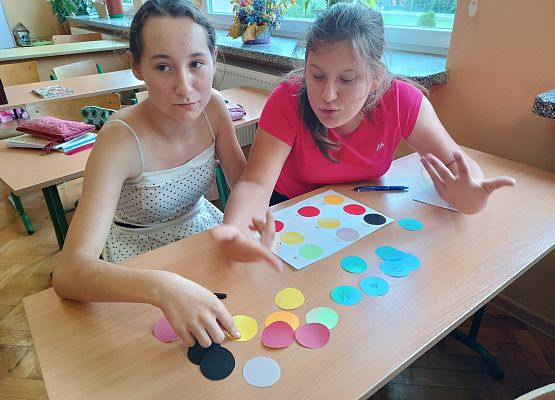 Dziewczynki rozkładają kropki z papieru