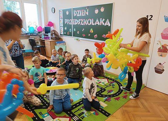 Uczennica rozdaje balony przedszkolakom