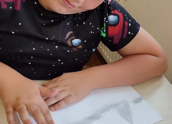 Chłopiec rysuje krajobraz górski