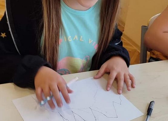 Dziewczynka rysuje krajobraz górski