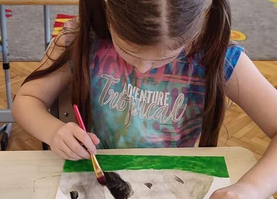 Dziewczynka rysuje krajobraz górski