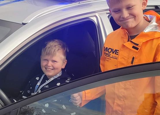 Chłopcy oglądają radiowóz