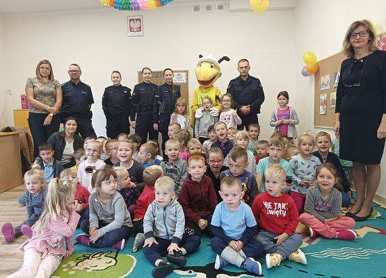 Grupowe zdjęcie przedszkolaków z policjantami i Mrówką